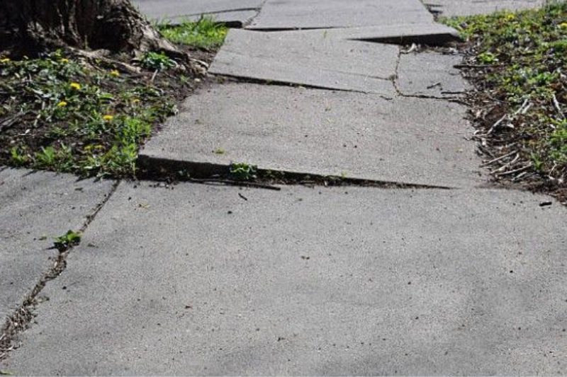 A sidewalk that has been broken in half.